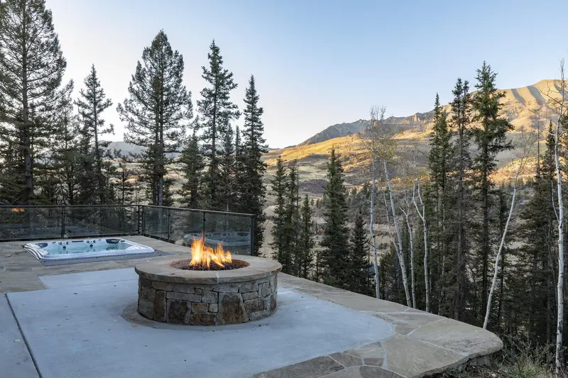 Fire pit and hot tub terrace at dusk, built by UltraBuilders near Telluride, Colorado