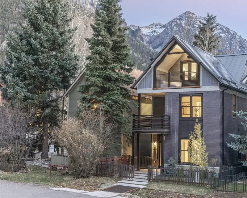 Custom home in Telluride, Colorado, built by UltraBuilders, lit at dusk beneath the peaks